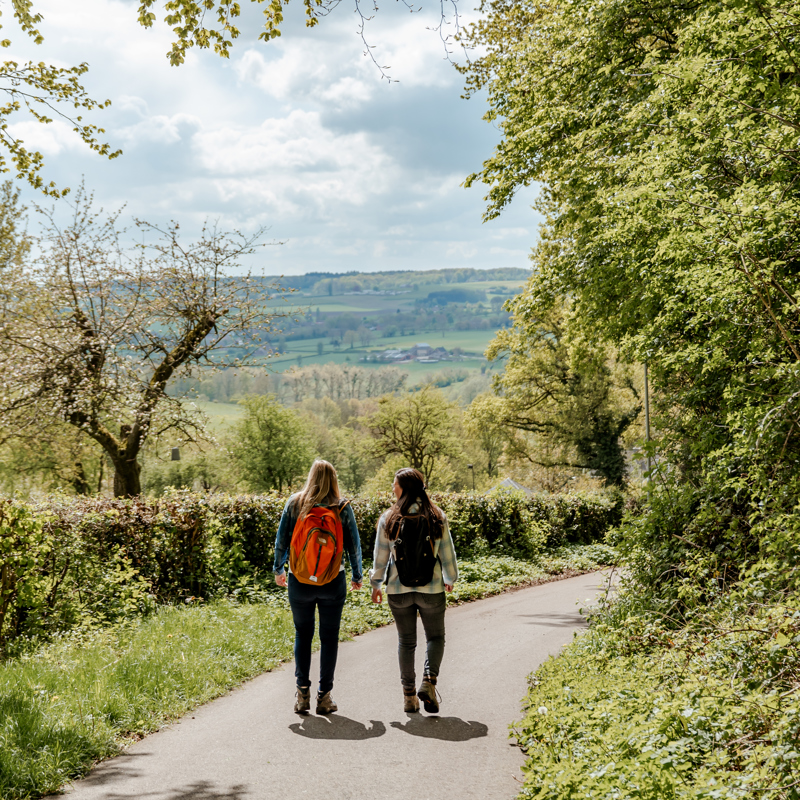 Twee sportieve vrouwen wandelen door heuvellandschap op een mooie lentedag