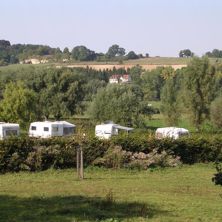 Weilanden met enkele caravans in het glooiende heuvelland.