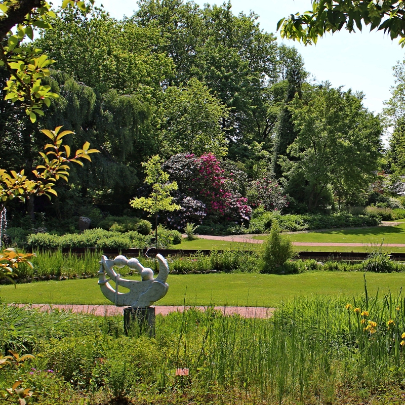 Een mooi onderhouden botanische tuin met beelden op een zonnige dag in Kerkrade.
