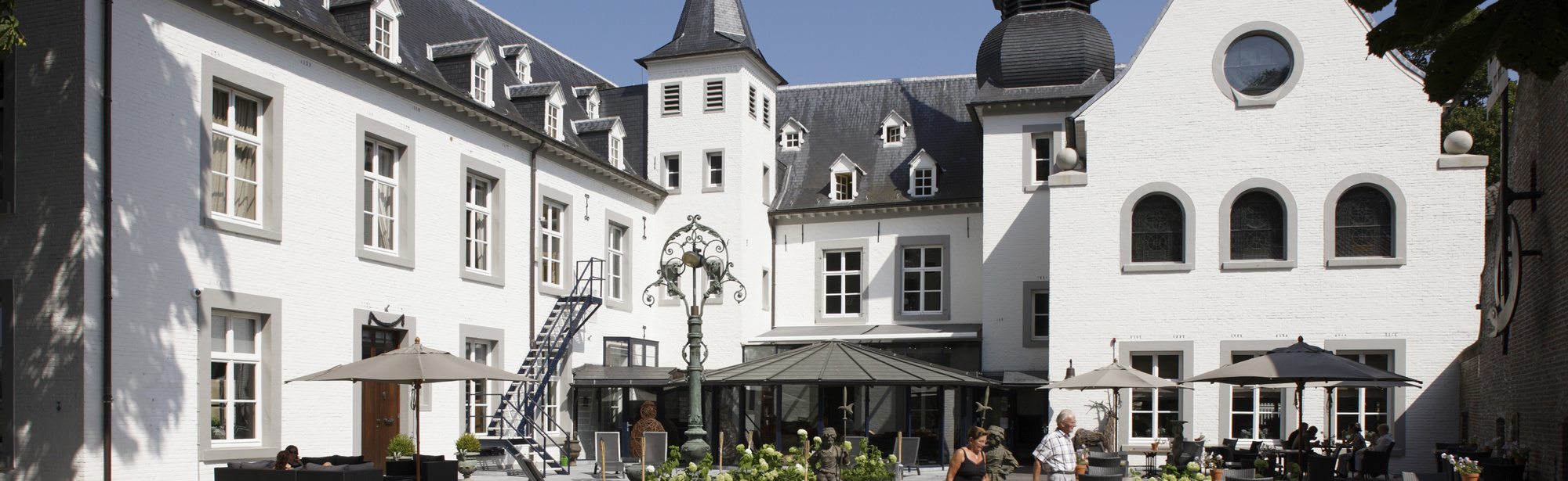 Chique modern wit kasteel in U-vorm met in het midden een terras. 