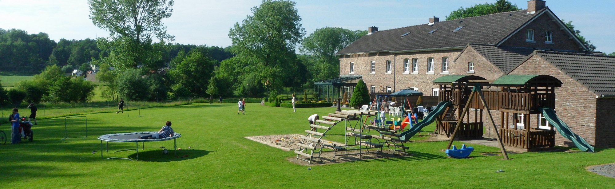 Groep accommodatie met grote grasweide en speelattracties. 