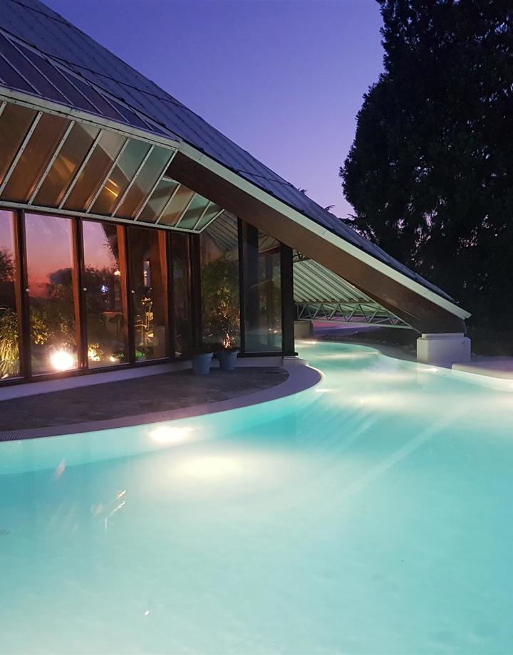 Verlicht buitenzwembad van Thermae 2000 tijdens vallende avond