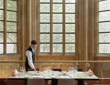 Ober die tafel indekt van Kruisheren restaurant met grote glas in lood ramen op de achtergrond in Maastricht