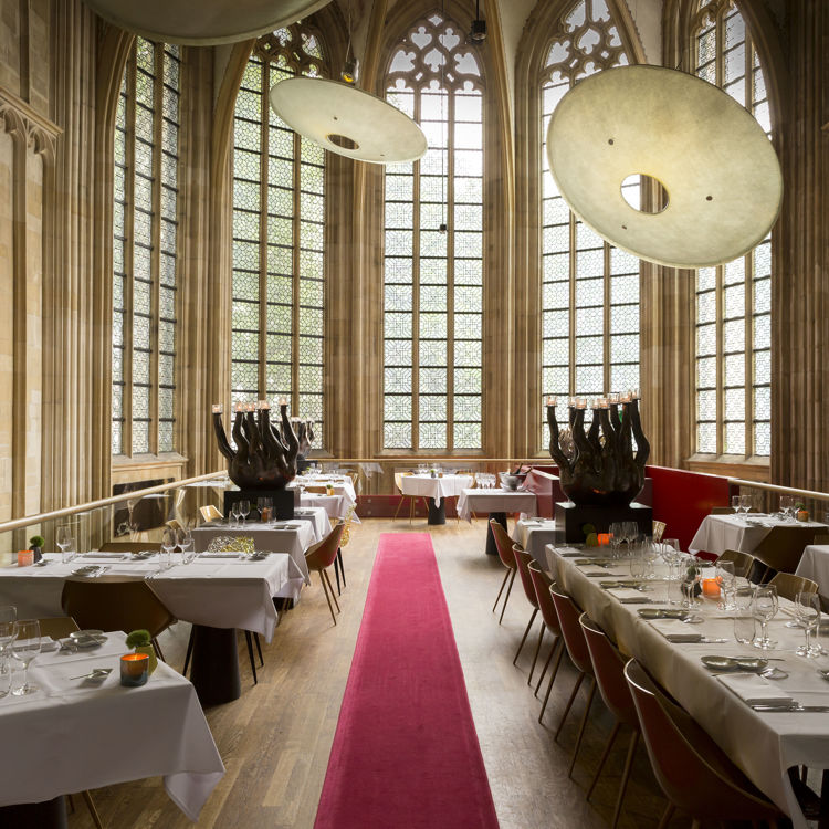 Kruisheren restaurant met grote glas in lood ramen op de achtergrond in Maastricht