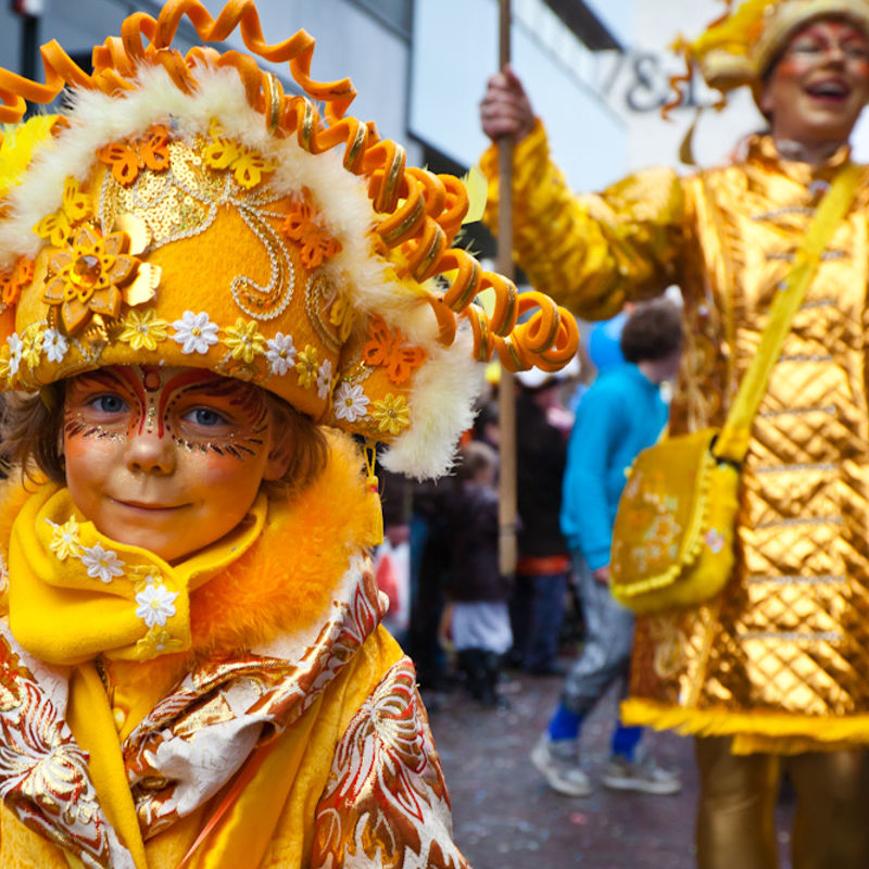 Kind verkleed en geschminckt in goud tinten tijdens Carnaval