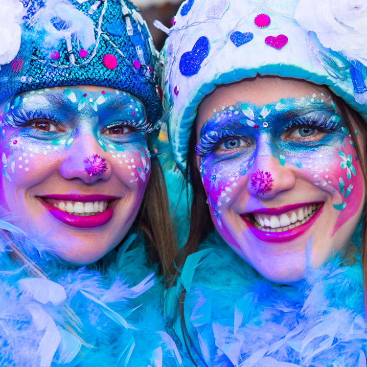 Twee vrouwens geschminckt in blauw en paars tinten met Carnaval