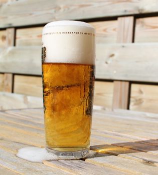 Detailopname van een glas bier op een houtentafel