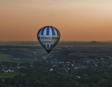 Luchtballon Boven Zuid Limburgs Heuvelland met een oranje lucht