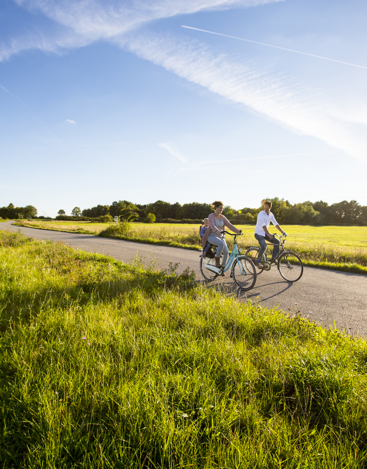 Moeder met kind achterop en vader fietsen door Zuid-Limburg