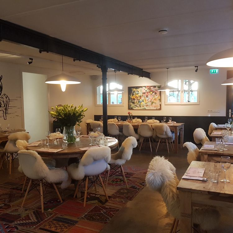 Inrichting van restaurant Heerdeberg met witte kuipstoeltjes met dierenvacht 