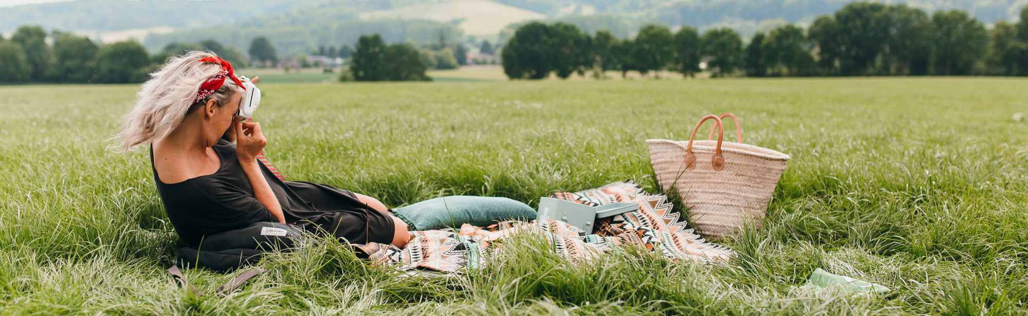 Vrouw liggende op picknickdeken met achterliggend heuvellandschap