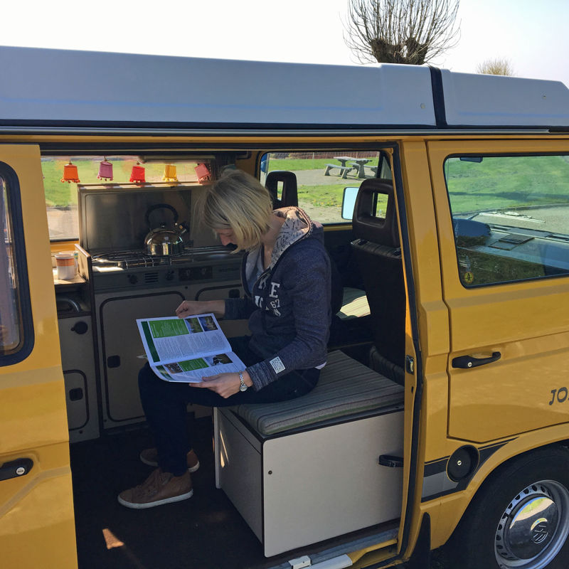 Maud de Graaff - Bloesemtocht zittende en lezende in gele Volkswagen