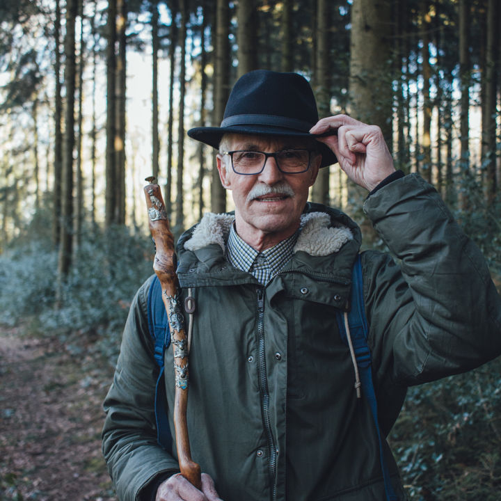 Wandelaar in Vijlenerbos met hoed en wandelstok close up