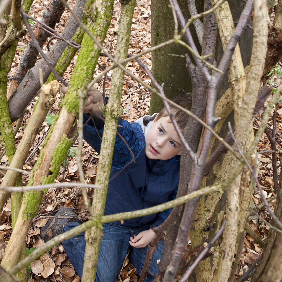 Kind zit in takkenhut in huttenbos bij Brunssummerheide