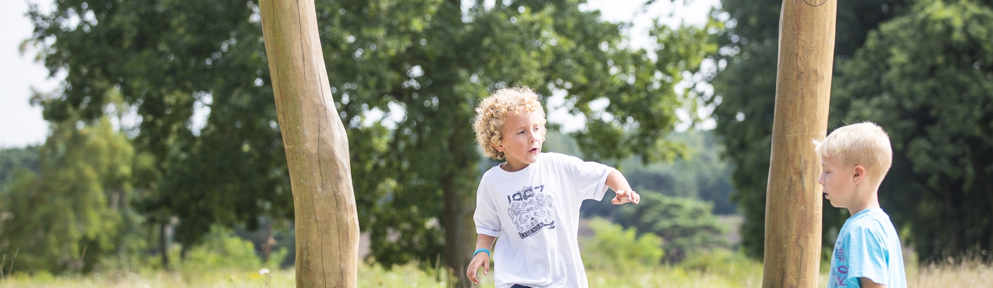 Kinderen spelen in een buitenspeeltuin in de natuur