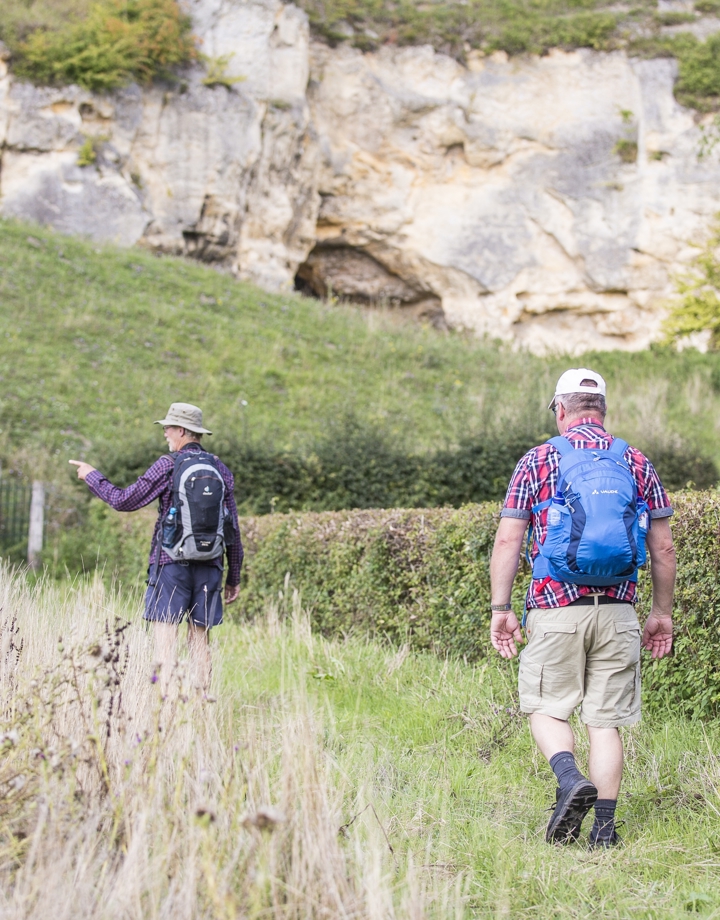 Twee wandelaars die richting de krijtwanden lopen