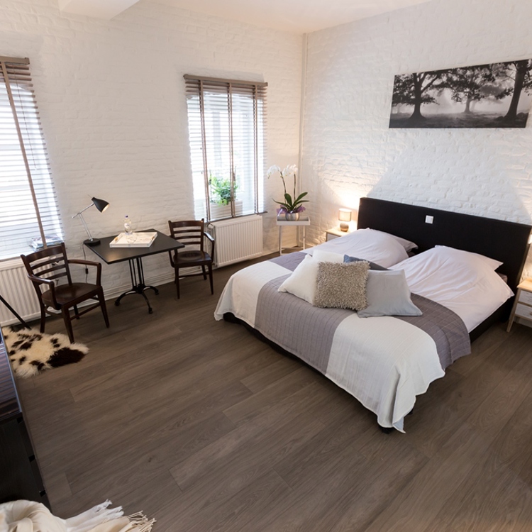 sfeervolle hotelkamer met opgemaakt bed.