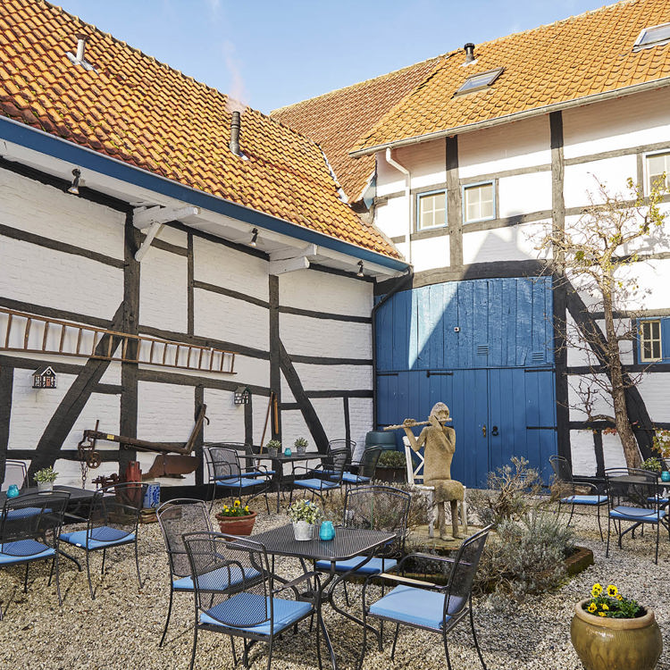 Binnenplaats van van een vakwerkwoning met blauw details.