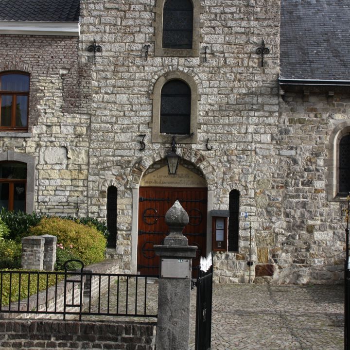 De entree met rode houten deur van de Lanbertuskerk in Holset - Vaals