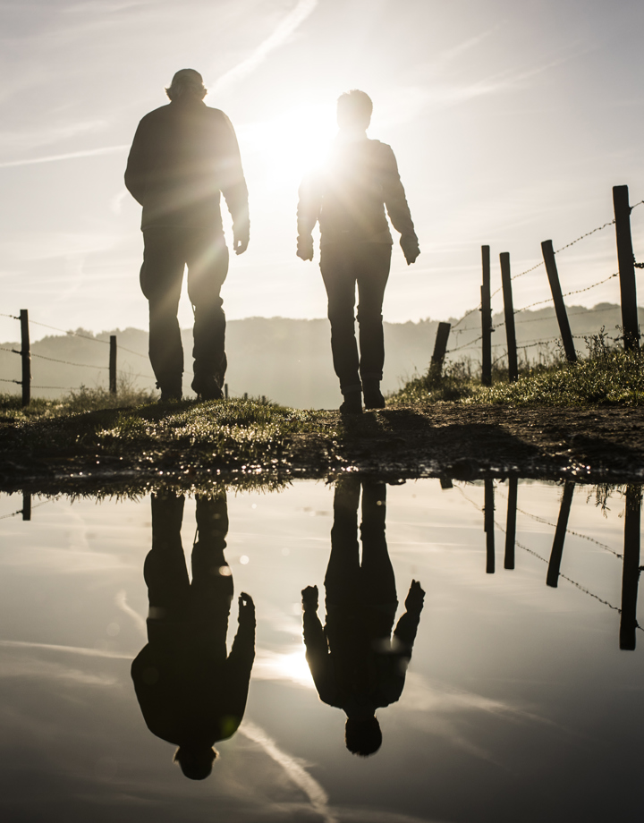 Wandelaars met reflectie in een waterplas