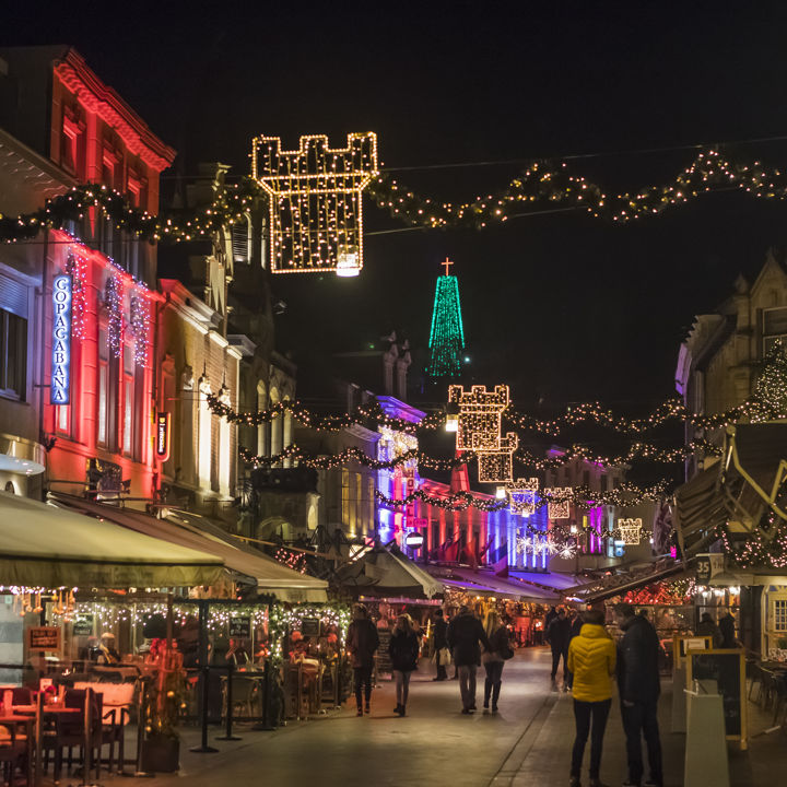 Mensen wandelen door de grote versierde straat in Valkenburg tijdens kerst