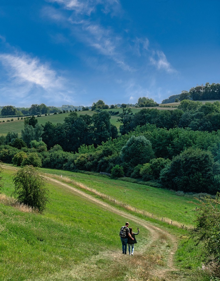 Twee wandelaars lopen op een pad met uitzicht over Noorbeek