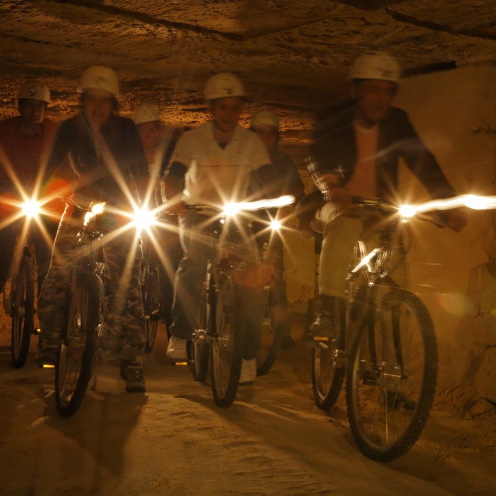 een groep is aan het grotbiken in de groeves van Valkenburg.