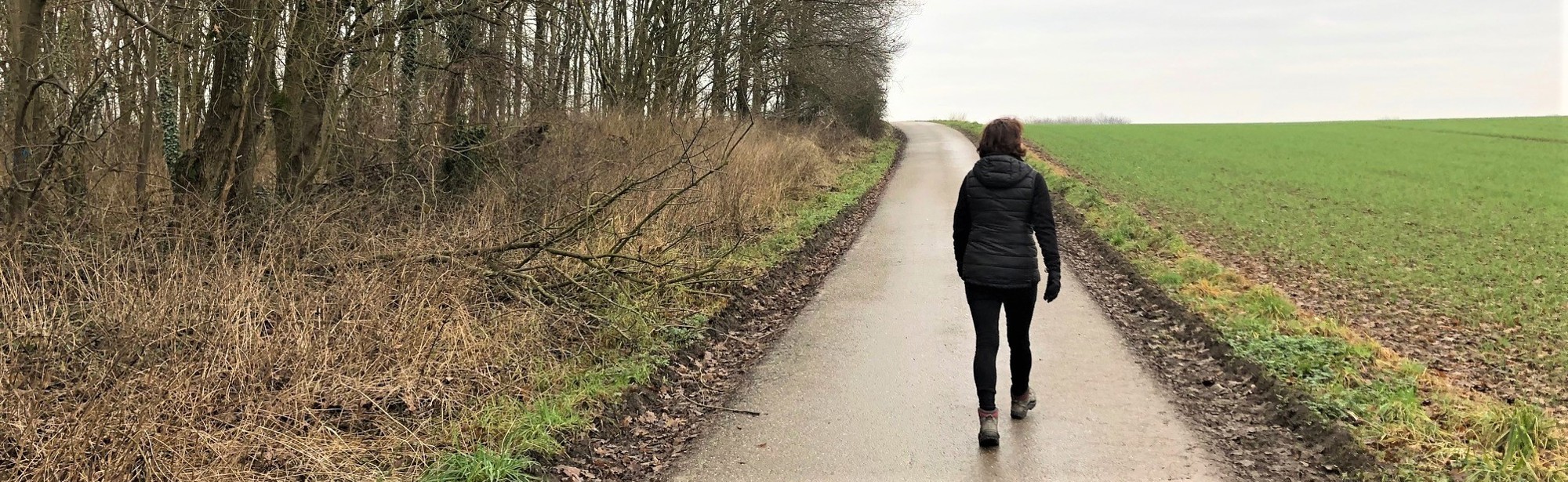 Een vrouw wandelt over een geasfalteerd wandelpad