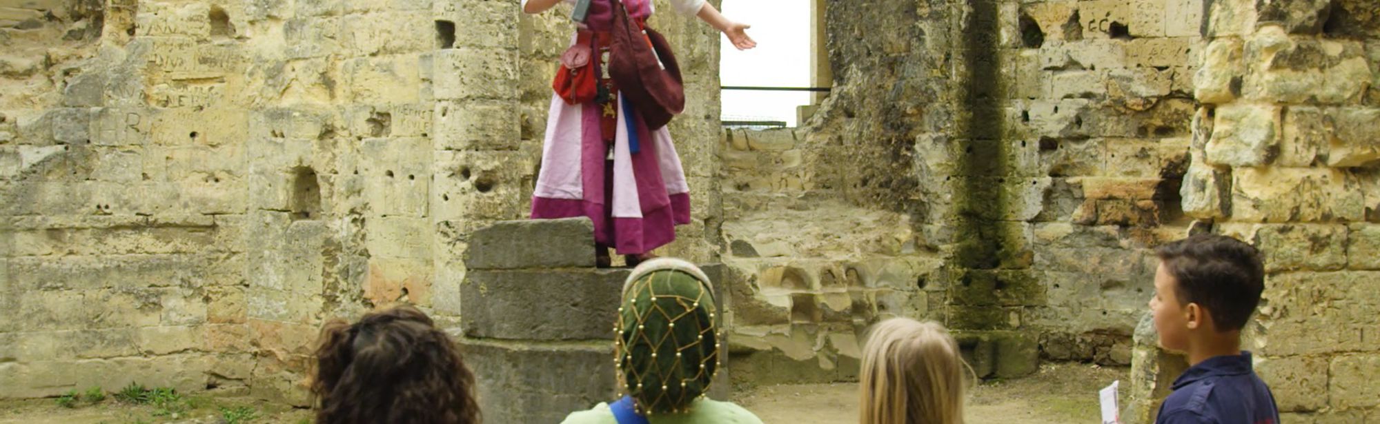 Verkleed kind spreekt haar vriendjes toe op een steenblok