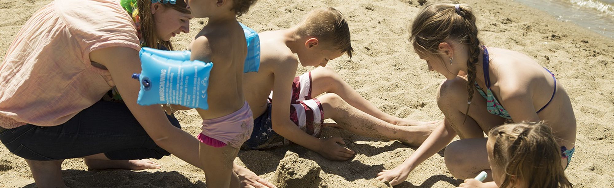 Kinderen spelen met zand op het strand bij FunValley