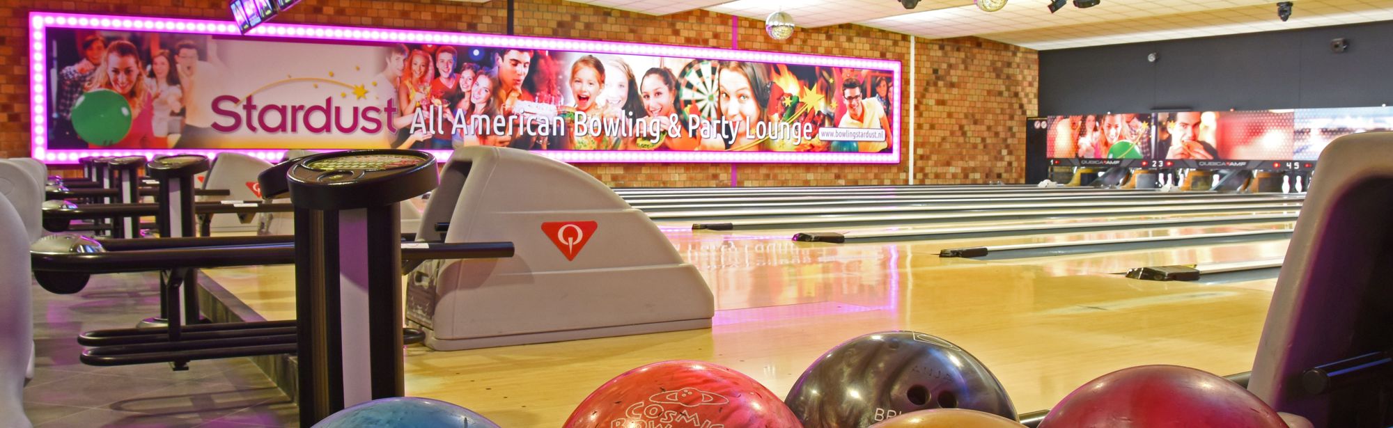 Detailopname van bowlingballen met op de achtergrond bowlingbanen