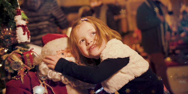 Meisje knuffelt kerstman in Kerststad