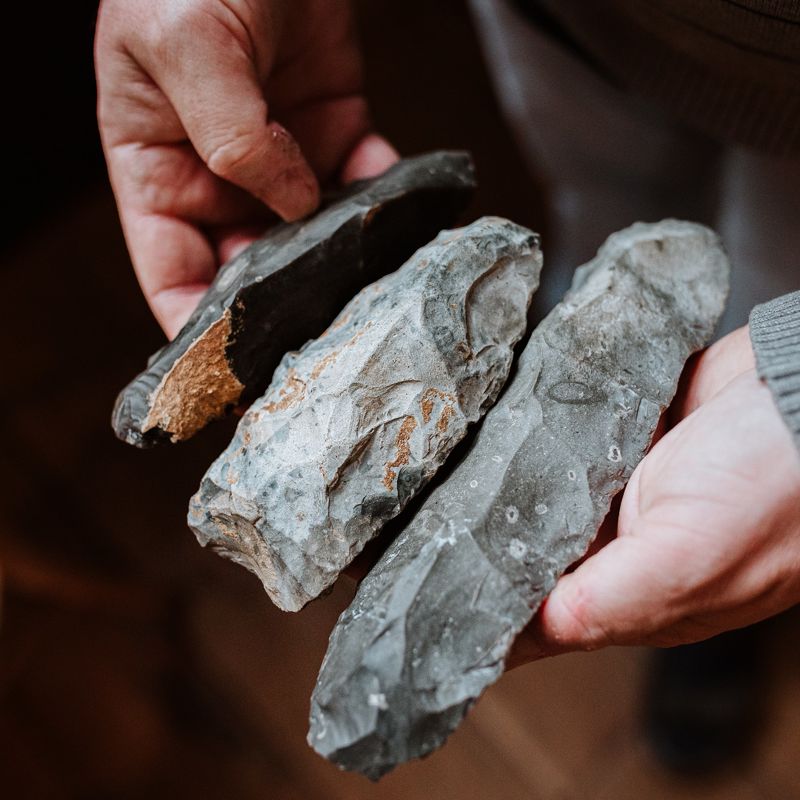 Joep Orbons laat een aantal prehistorische stenen zien in zijn handen