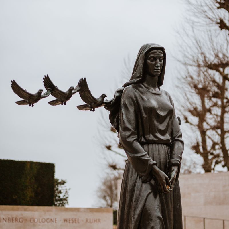 Herdenkingsmonument van een vrouw met drie vrijheidsduiven op de Amerikaanse Begraafplaats in Margraten