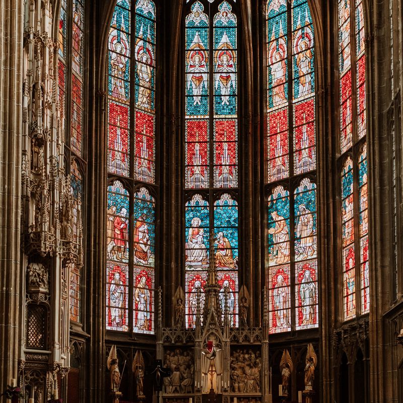 Een vooraanzicht van prachtige glas-in-lood ramen en het altaar in een basiliek 