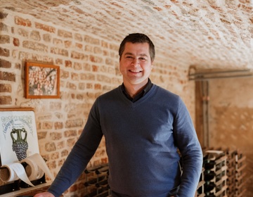Maurice Warnier poseert in een wijnkelder