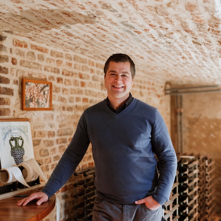 Maurice Warnier poseert in een wijnkelder