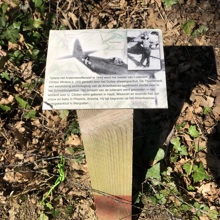 Kleine plaquette op een houten zuil met infomatie ovver Clinton Winters jr.