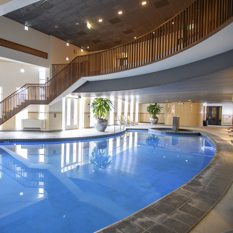 Zwembad in een hotel met bovenlangs een reling.