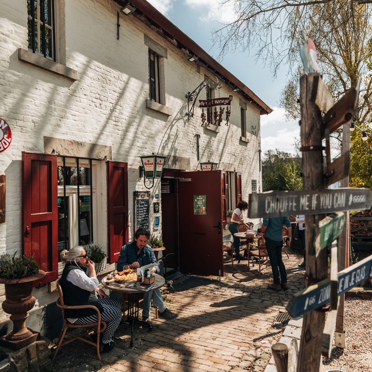 Mensen genieten van een lunch aan een tafeltje op het terras van de Vief Heringe 