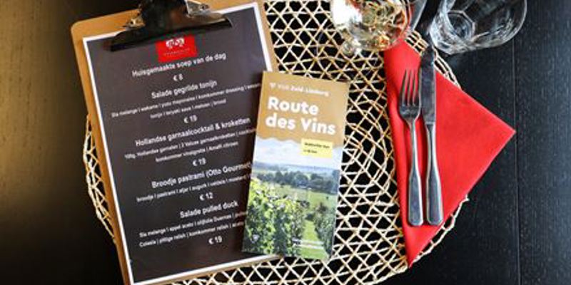 Gedekte tafel met een folder van Route Des Vins