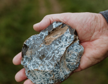 Een hand houdt een stuk vuursteen vast