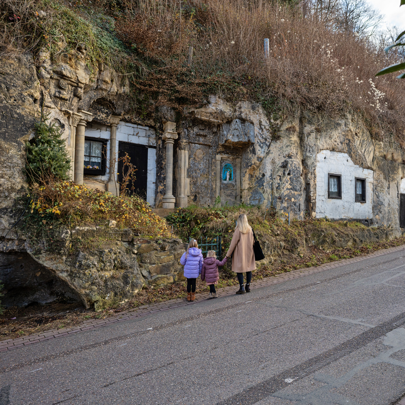 Woningen in Mergelwand met drie personen kijkend
