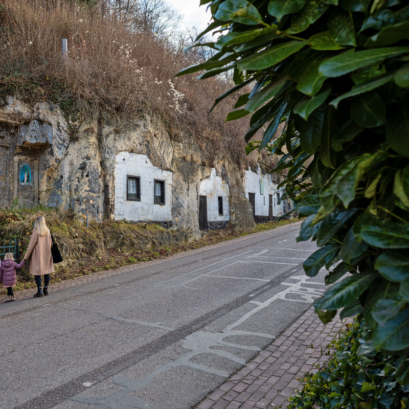 Woningen in Mergelwand met drie personen kijkend