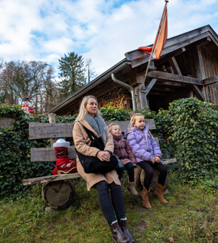 Vrouw en twee kinderen zittend op bankje in de winter