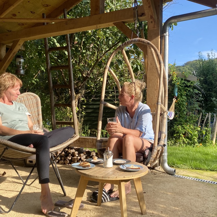 Twee mensen genieten buiten in de zon op terras van een koffie van demarragecoffee in slenaken
