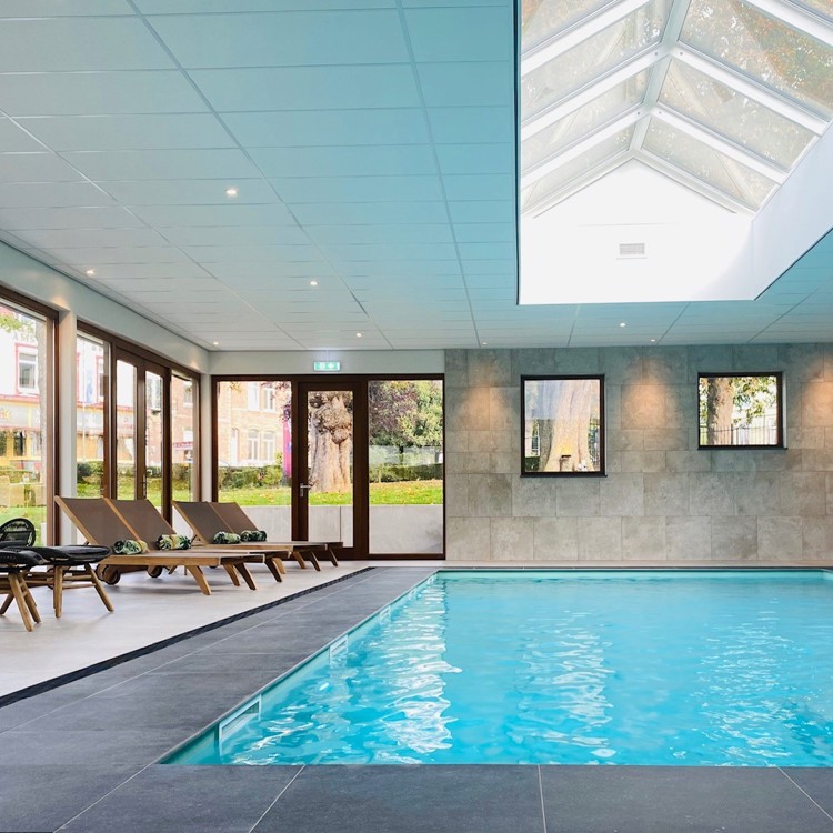 Zwembad met loungestoelen ernaast van Hotel Schaepkens van St. Fijt