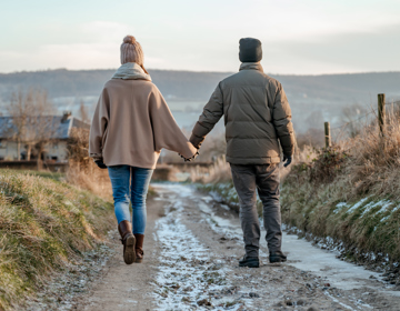 Twee mensen hand in hand wandelend door het Heuvelland in de winter