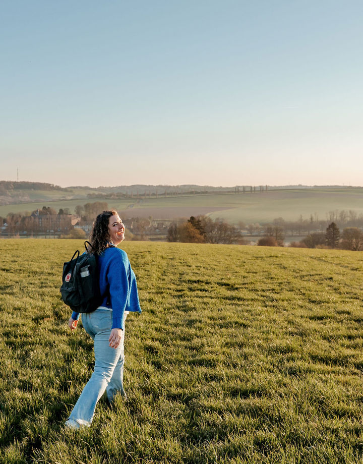 Lachende vrouw in groene weide met uitzicht