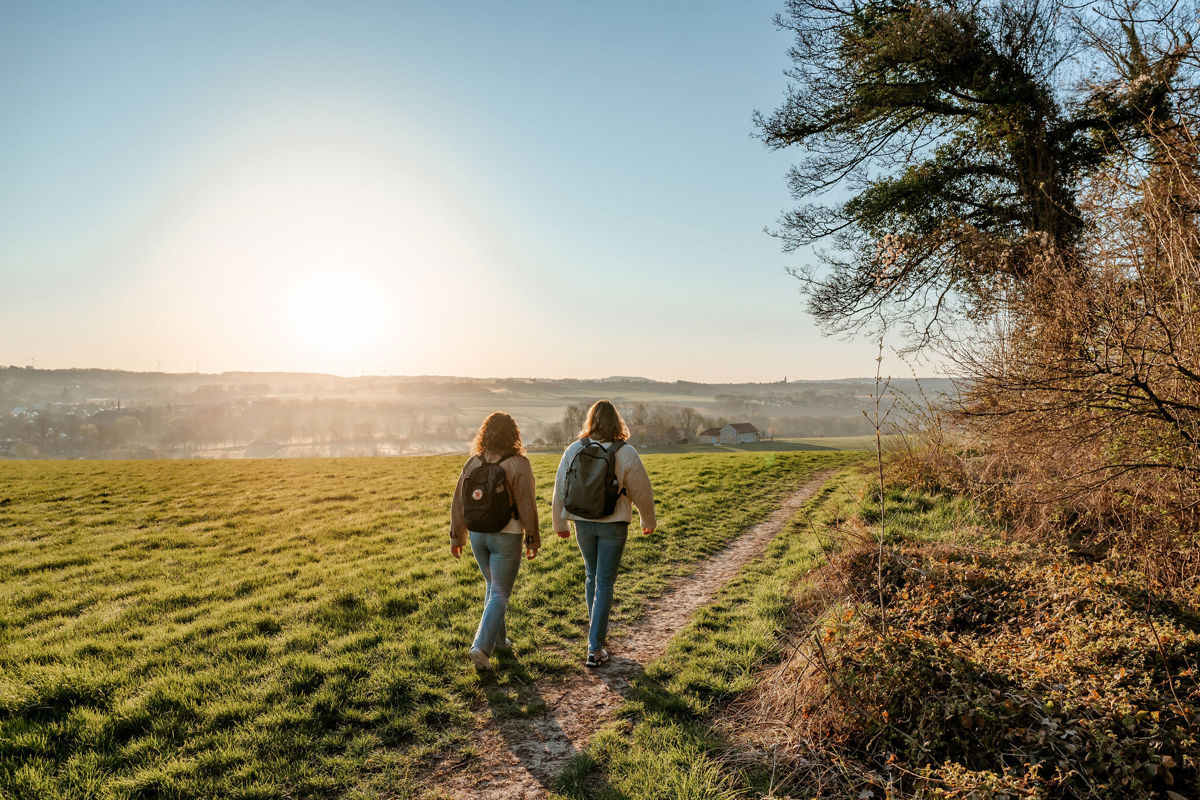 Wandelaars op een wandelpad bij zonsopkomst rondom de Gulperberg